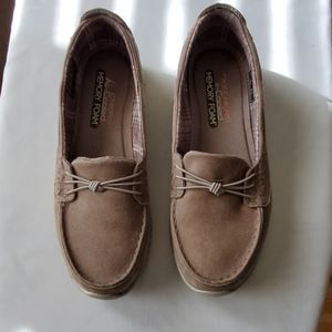 Tan Skechers loafers.